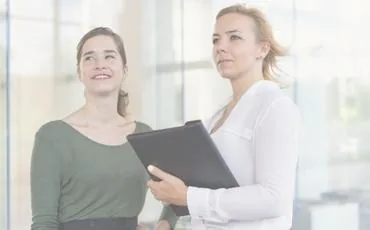 Dos profesionales revisando documentación de un cliente